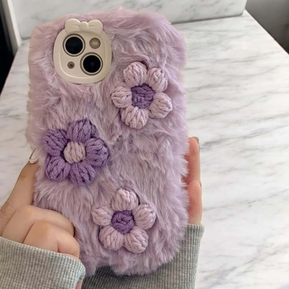 a person holding a cell phone case with flowers on it