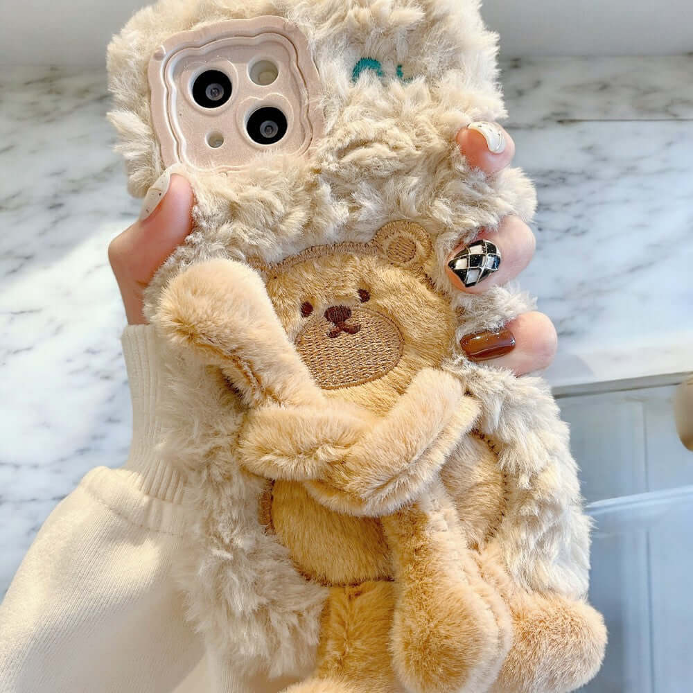 a person holding a teddy bear phone case