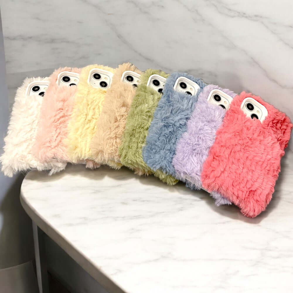 a row of fuzzy phone cases sitting on top of a counter