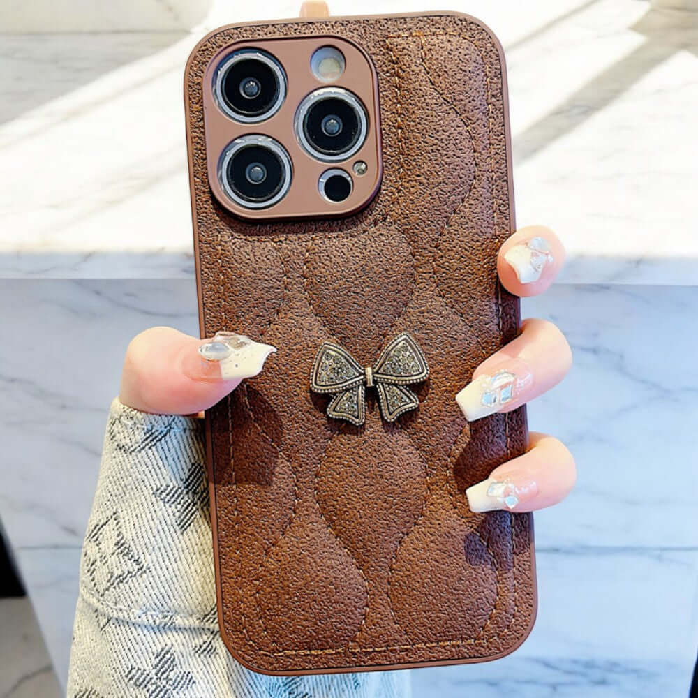 a woman holding a brown case with a bow on it