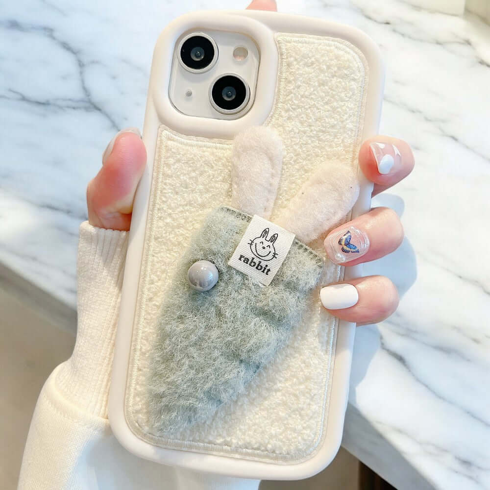 a woman holding up a phone case with a bunny on it