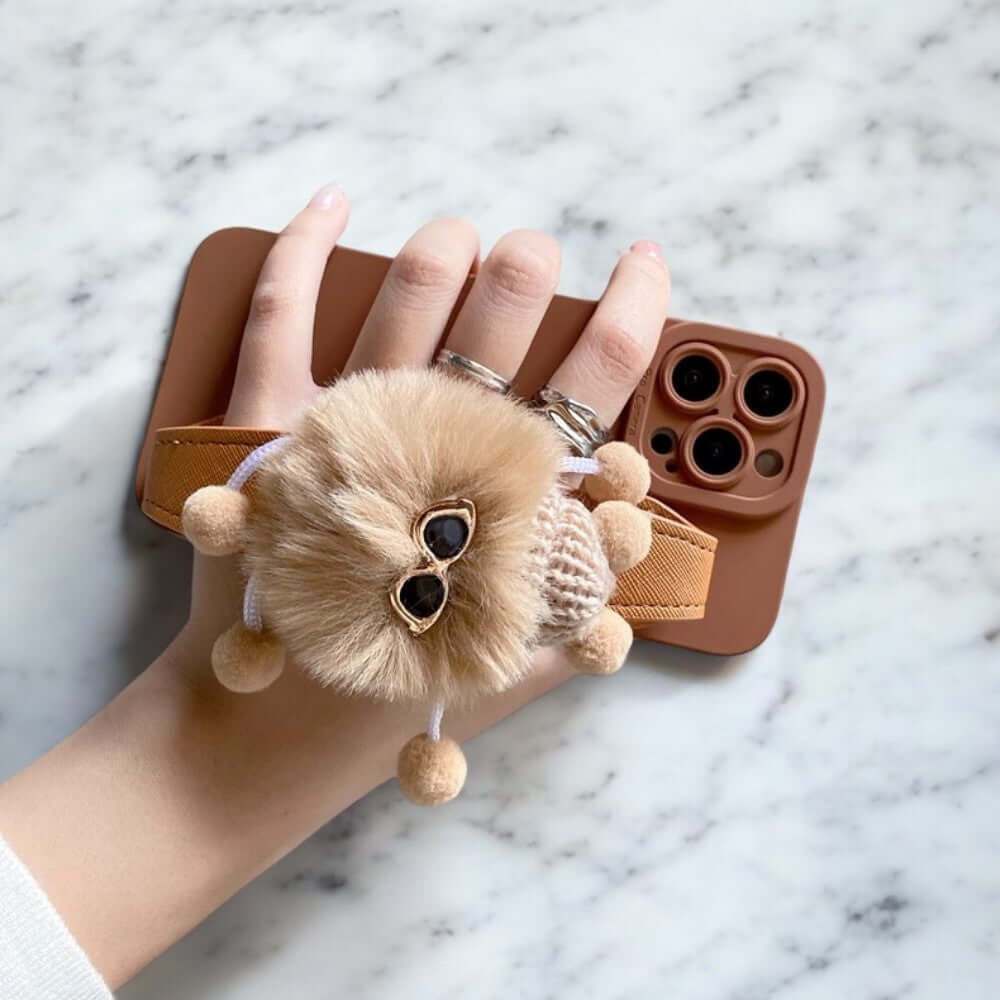 a person's hand holding a phone case with a teddy bear on it