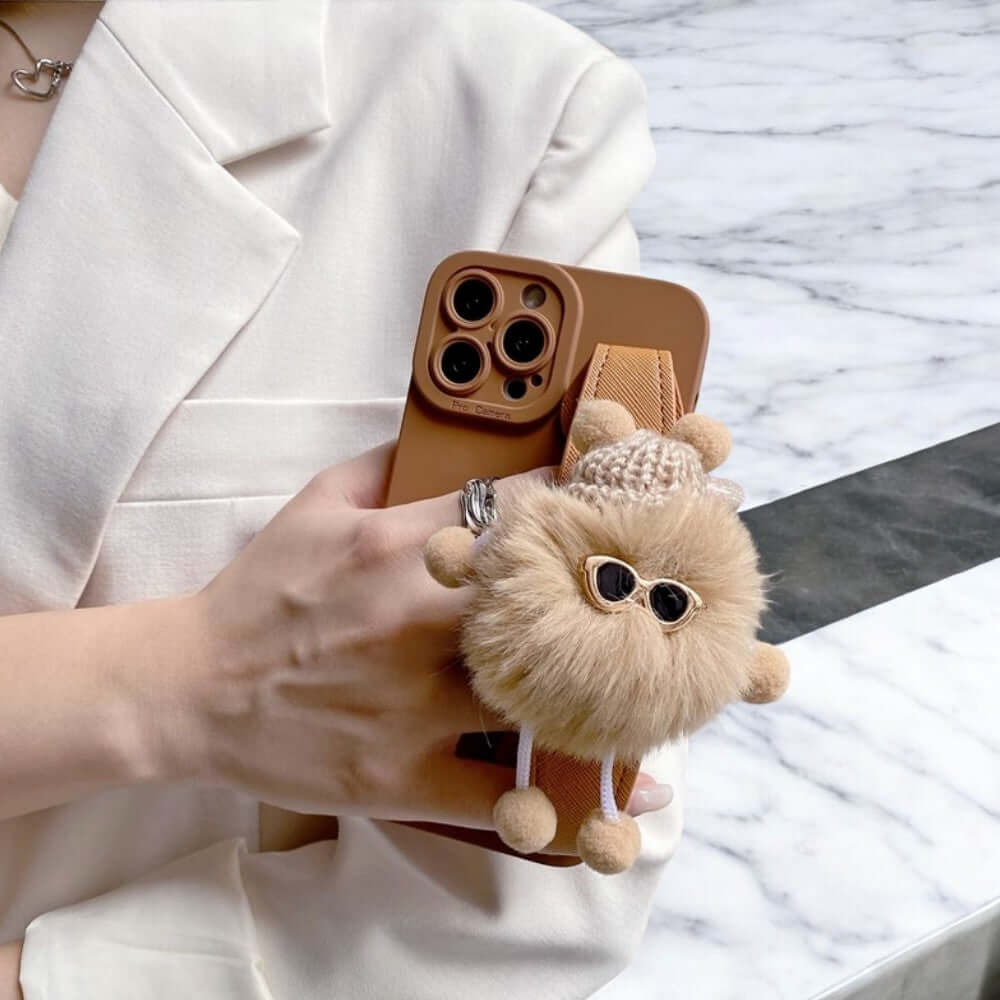 a woman holding a phone case with a stuffed animal in it