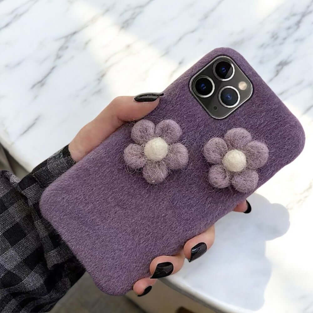 a woman holding a purple phone case with flowers on it