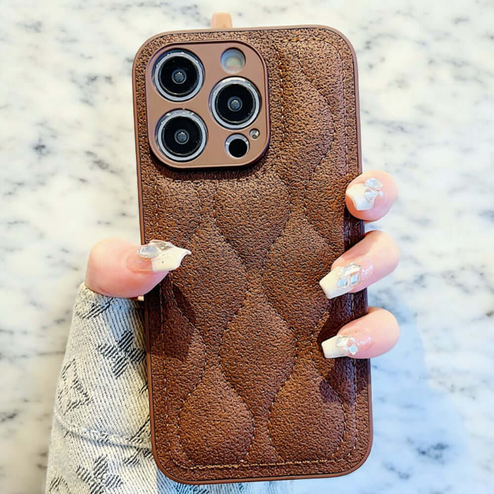 a woman's hand holding a brown cell phone case