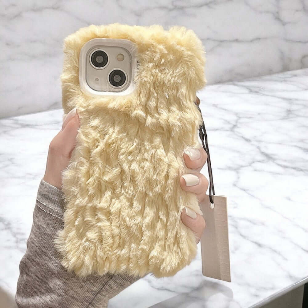 a person holding a cell phone in a fuzzy case