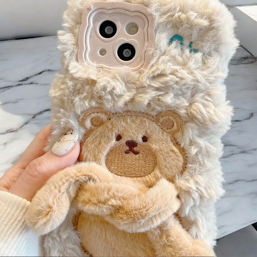 a person holding a phone case with a teddy bear on it