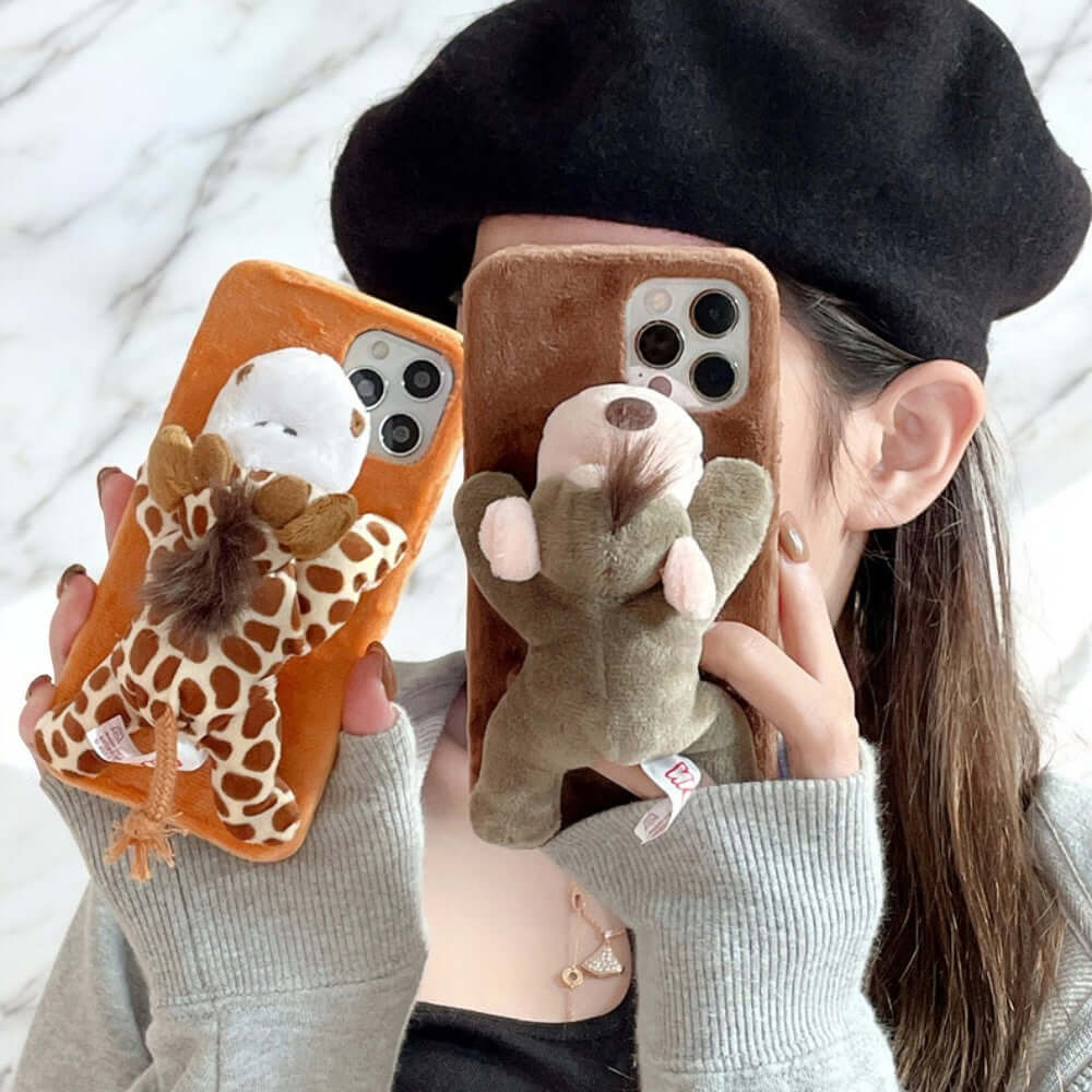 a woman holding a phone case with a stuffed animal on it