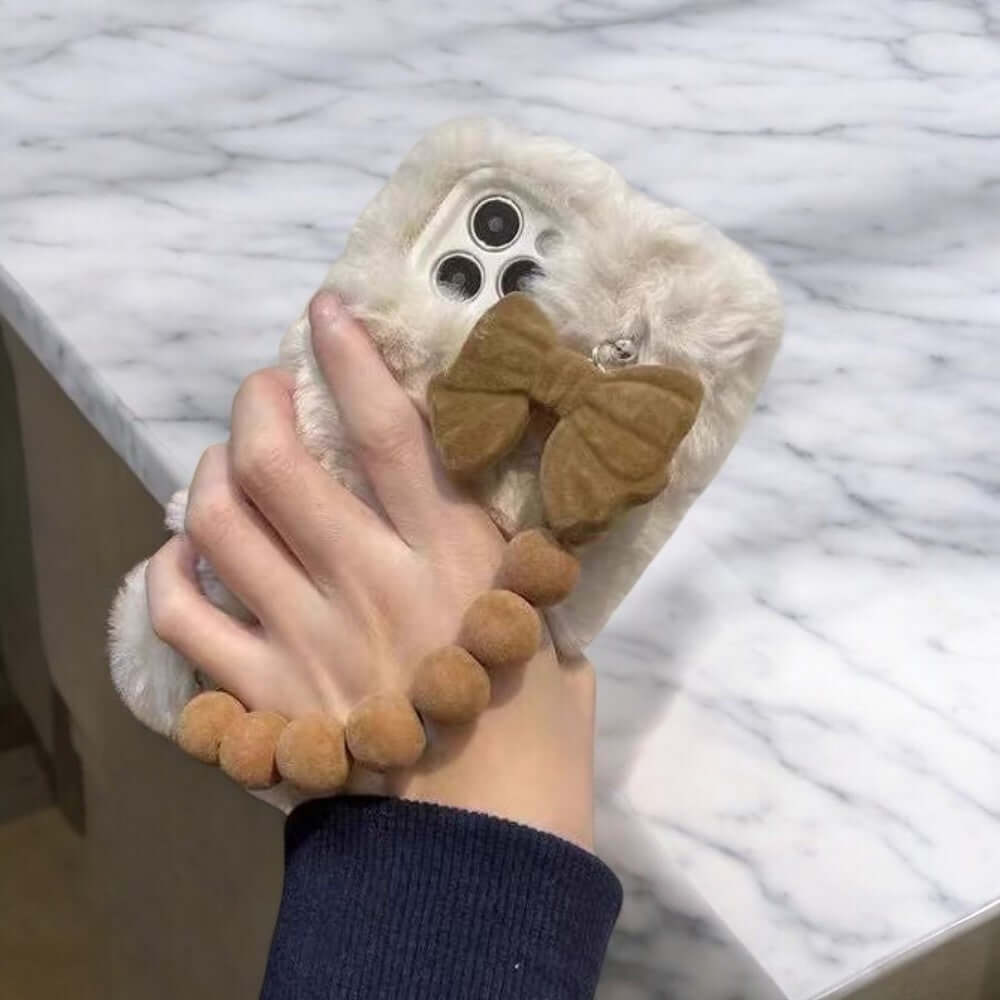 a person holding a cell phone with a stuffed animal on it