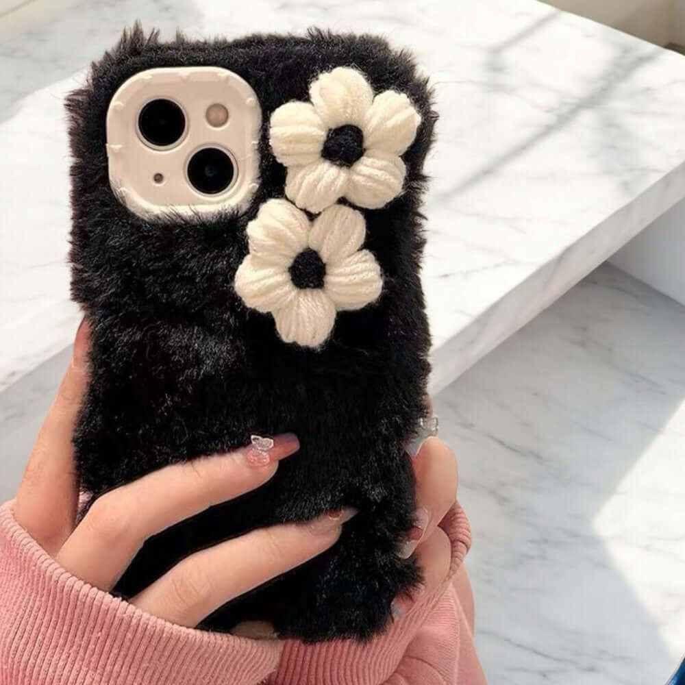 a woman holding a cell phone case with flowers on it