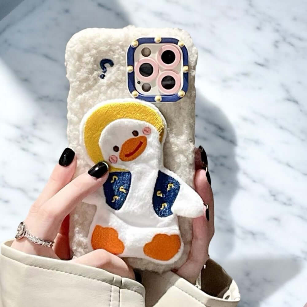 a woman holding a phone case with a penguin on it